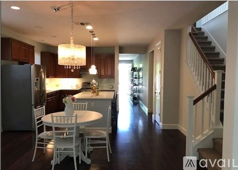A kitchen with a table and chairs and a staircase.