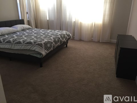 A bedroom with a large bed and a desk.