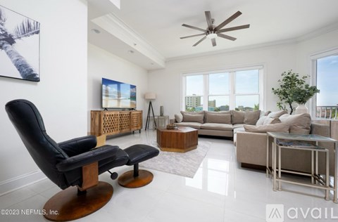 A living room with a black leather chair and a wooden coffee table.