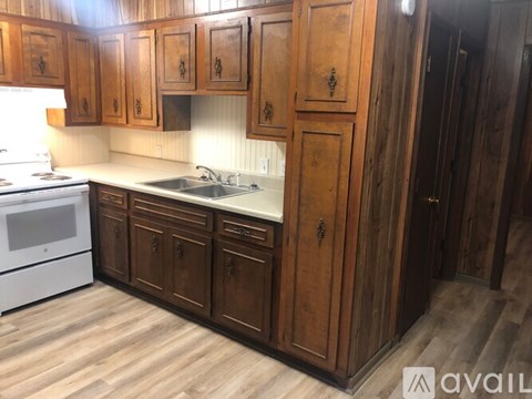 A kitchen with wooden cabinets and a white stove.