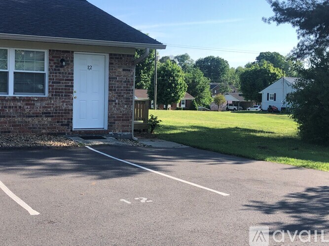 A house number 12 with a white door and a driveway with a white arrow.