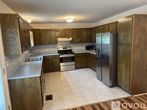 A kitchen with wooden cabinets and stainless steel appliances.