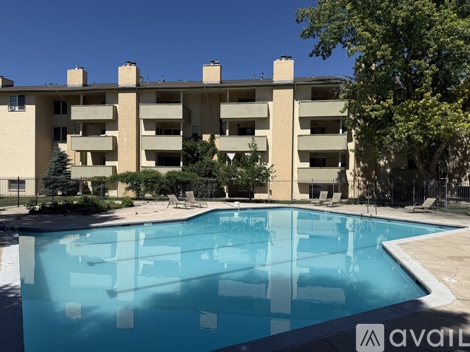 A large swimming pool in front of a multi-story apartment building.