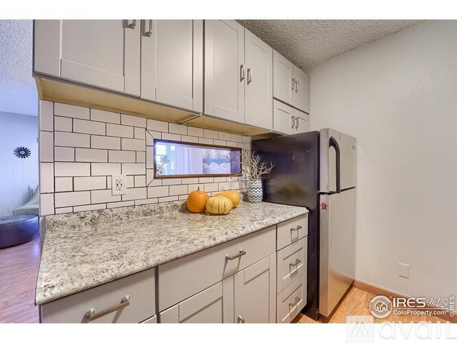 A kitchen with white cabinets and a granite countertop.