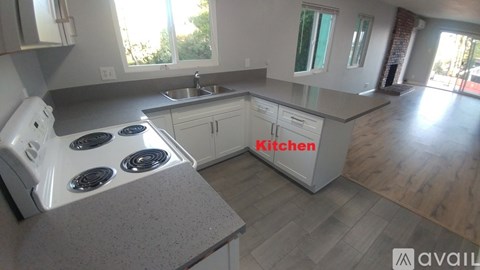 A kitchen with a stove top oven and a sink.
