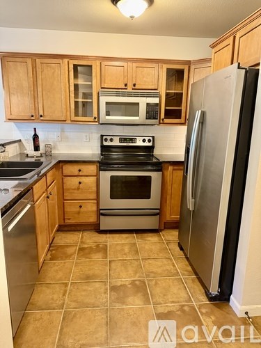 A kitchen with wooden cabinets and a tile floor.