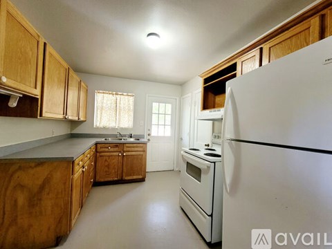 A kitchen with wooden cabinets and a white refrigerator.