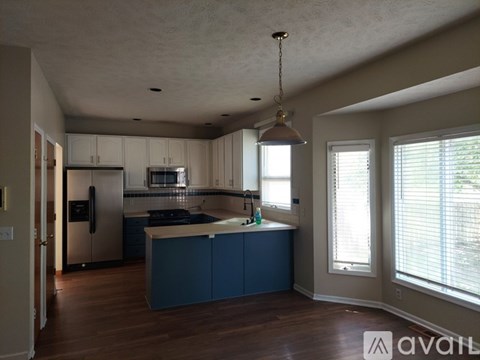 A kitchen with blue cabinets and a wooden floor.