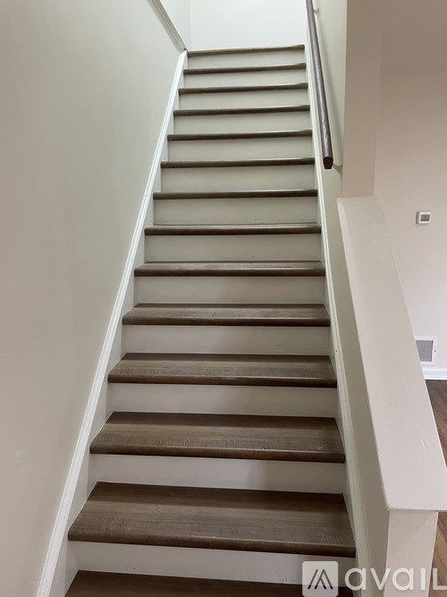 A staircase with wooden steps and white railings.