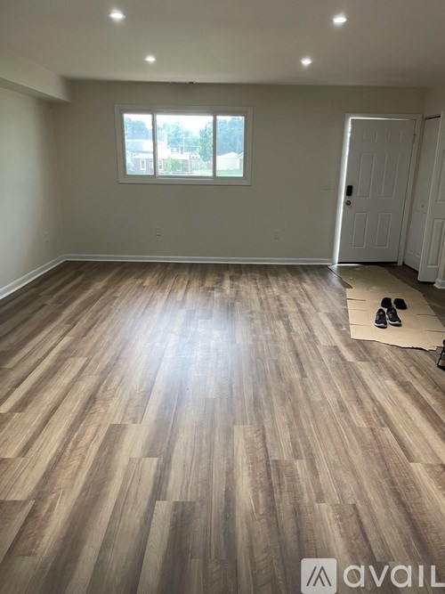 A room with wooden flooring and a window.
