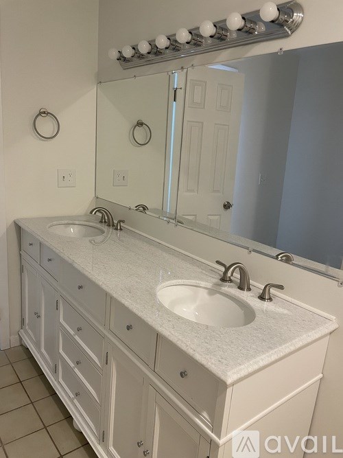 A bathroom with a white sink and a mirror above it.