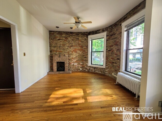 A room with wooden floors and two windows is available for rent.