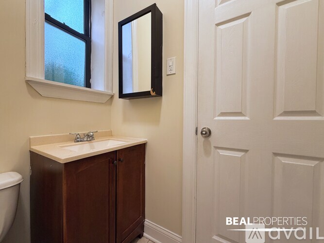 A bathroom with a sink, mirror, and toilet.