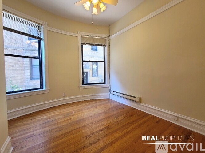 A long hallway with wood floors and white walls.
