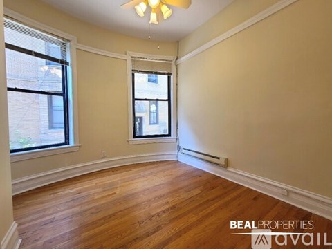 A long hallway with wood floors and white walls.