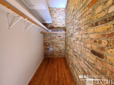 A room with wooden floors and a window with a view of a building outside.