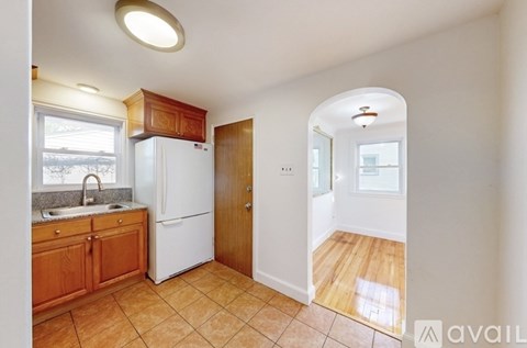 A kitchen with a white refrigerator and wooden cabinets.