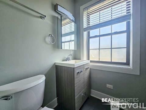 A room with a ceiling fan and two windows.