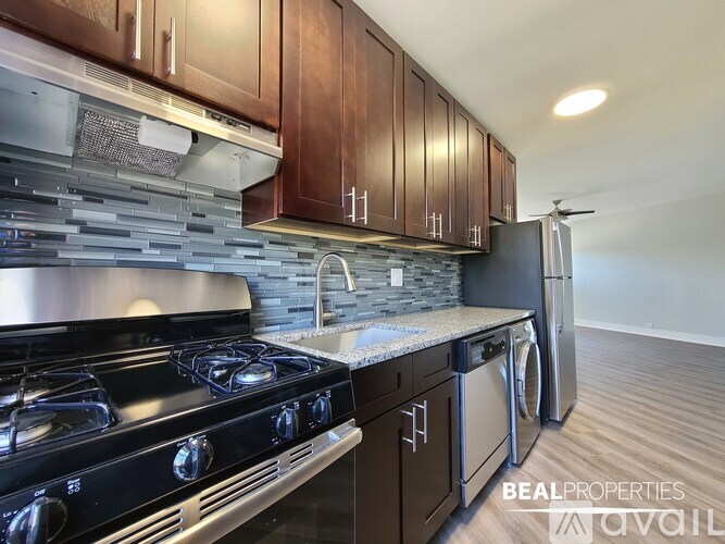A modern kitchen with dark wood cabinets and stainless steel appliances.