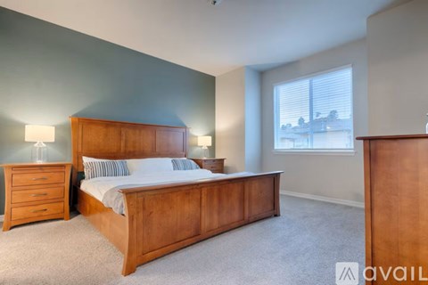 A bedroom with a bed, nightstand, and lamp.