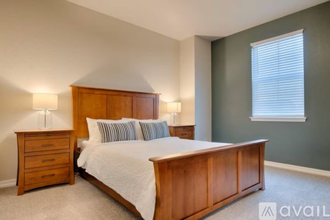 A bedroom with a bed, nightstand, and lamp.