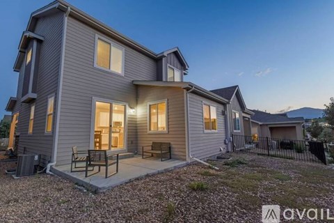 A modern house with a grey exterior and a patio area.