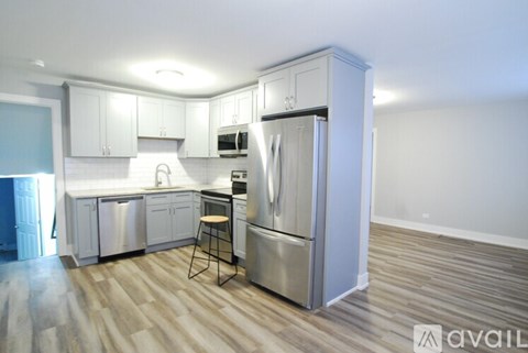 A kitchen with white cabinets and a wooden floor.