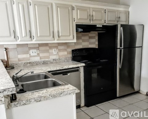 A kitchen with a black fridge and a black oven.