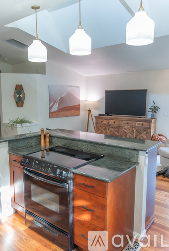 A kitchen with a black stove top oven and a wooden counter top.