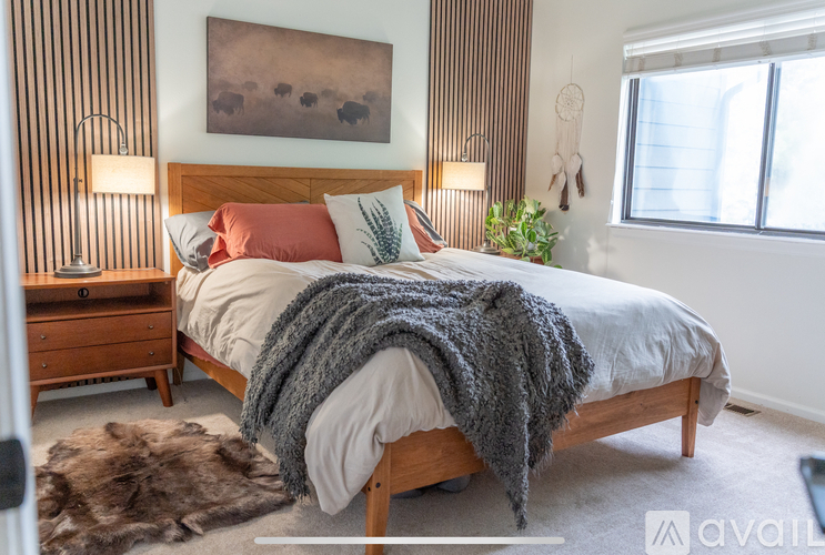 A bedroom with a large bed and a painting on the wall.