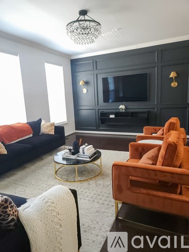 A living room with a black couch and a television.