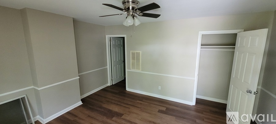 A room with a ceiling fan and a doorway leading to another room.