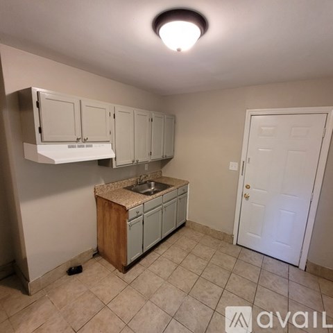 A kitchen with white cabinets and a wooden island.