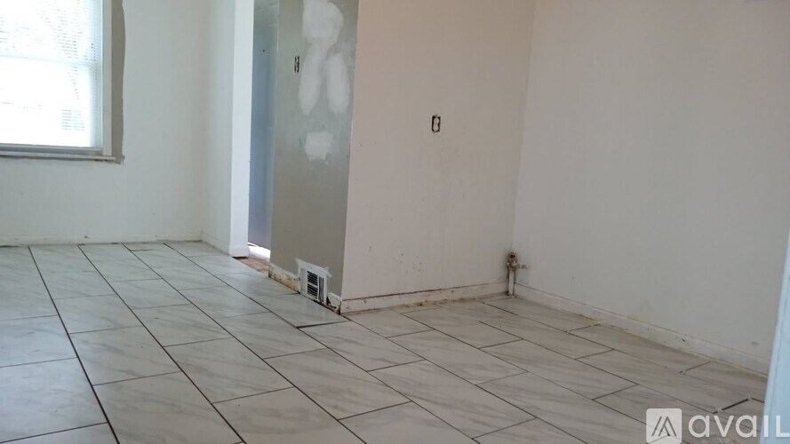 A room with a tiled floor and a wall with a hole in it.