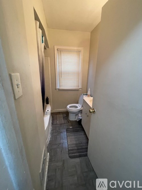 A small bathroom with a toilet and a window.
