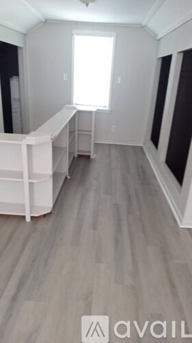 A room with a window and a white cabinet.