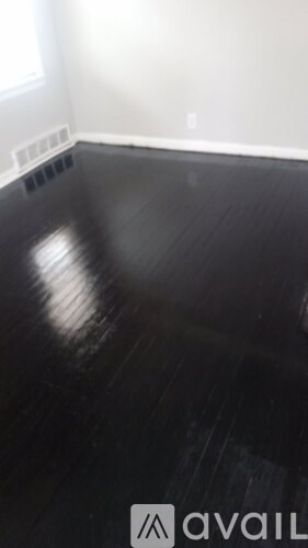 A room with a black floor and a white wall.