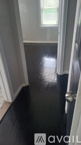 A hallway with a black floor and white walls.