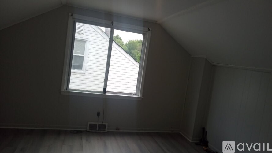 A room with a window and a sign that says "available".