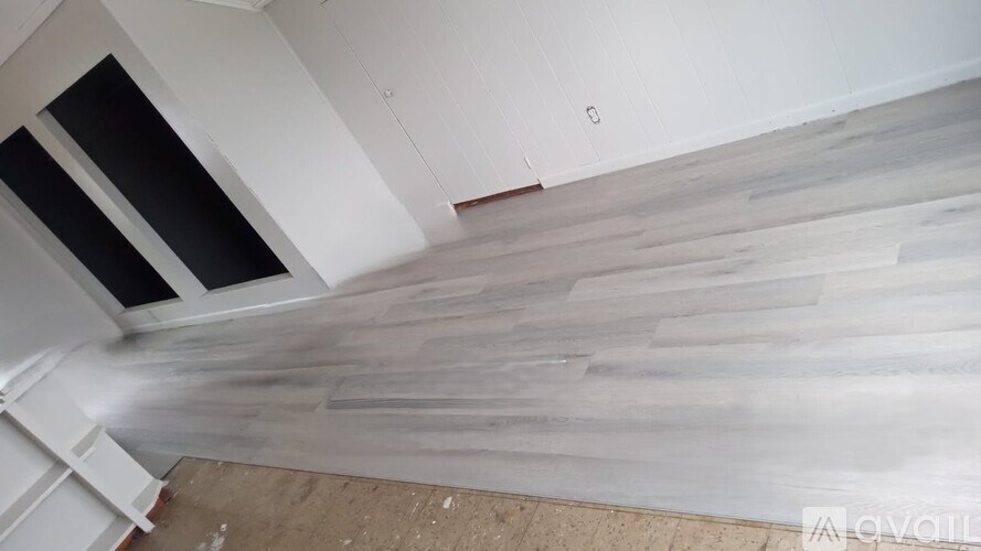 A room with a wooden floor and a skylight.