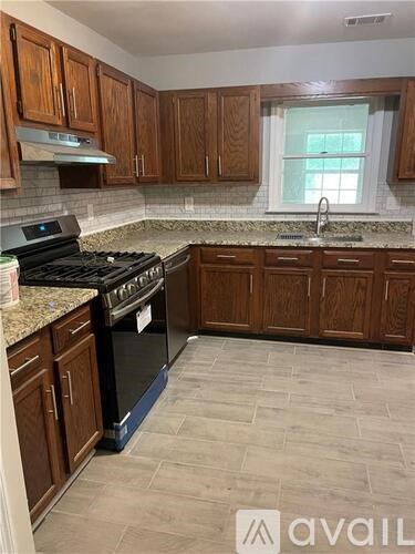 A kitchen with wooden cabinets and a black stove top oven.