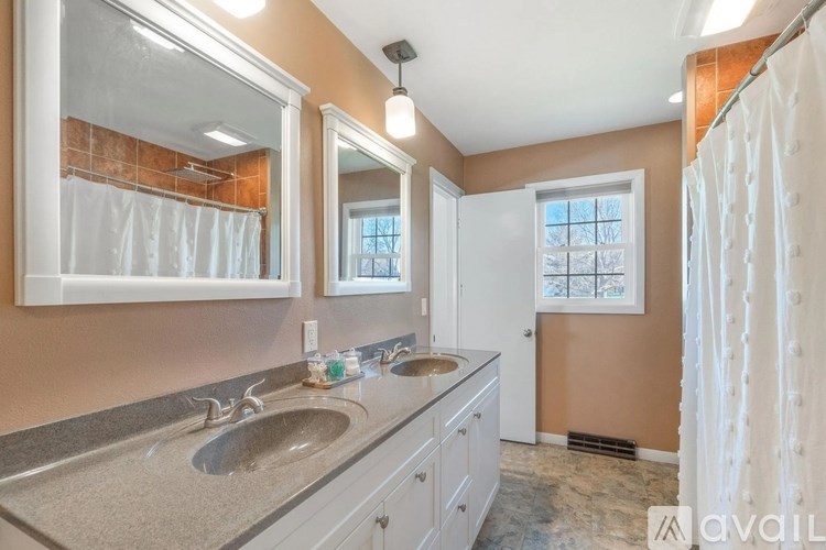 A bathroom with a double sink vanity and a shower with a glass door.