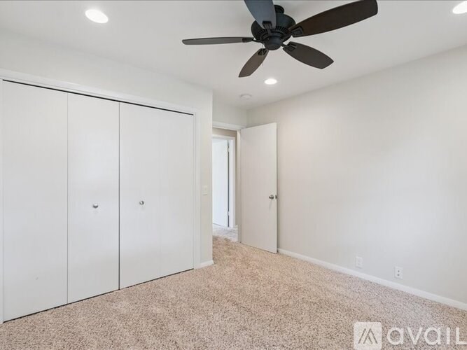 A kitchen with white cabinets and a wooden floor.