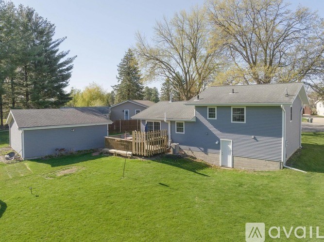 A house with a grey roof and a deck in the backyard.