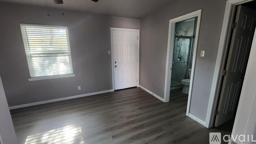 A room with a white door and a window with blinds.