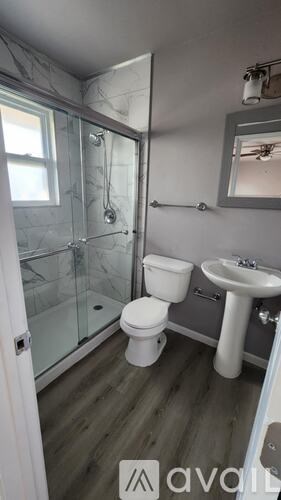 A bathroom with a toilet, sink, and shower.