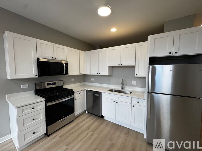 A kitchen with white cabinets and stainless steel appliances.