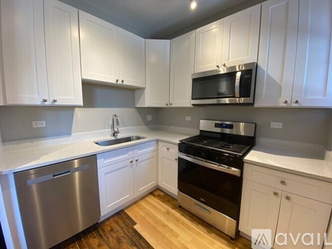 A kitchen with white cabinets and stainless steel appliances.