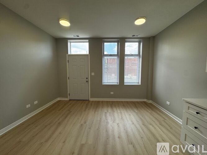 A room with wooden flooring and a white door.