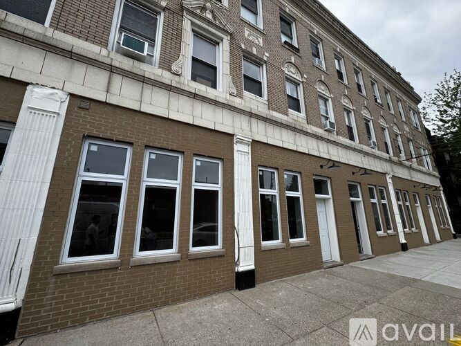 A building with a row of windows and a white column on the side.